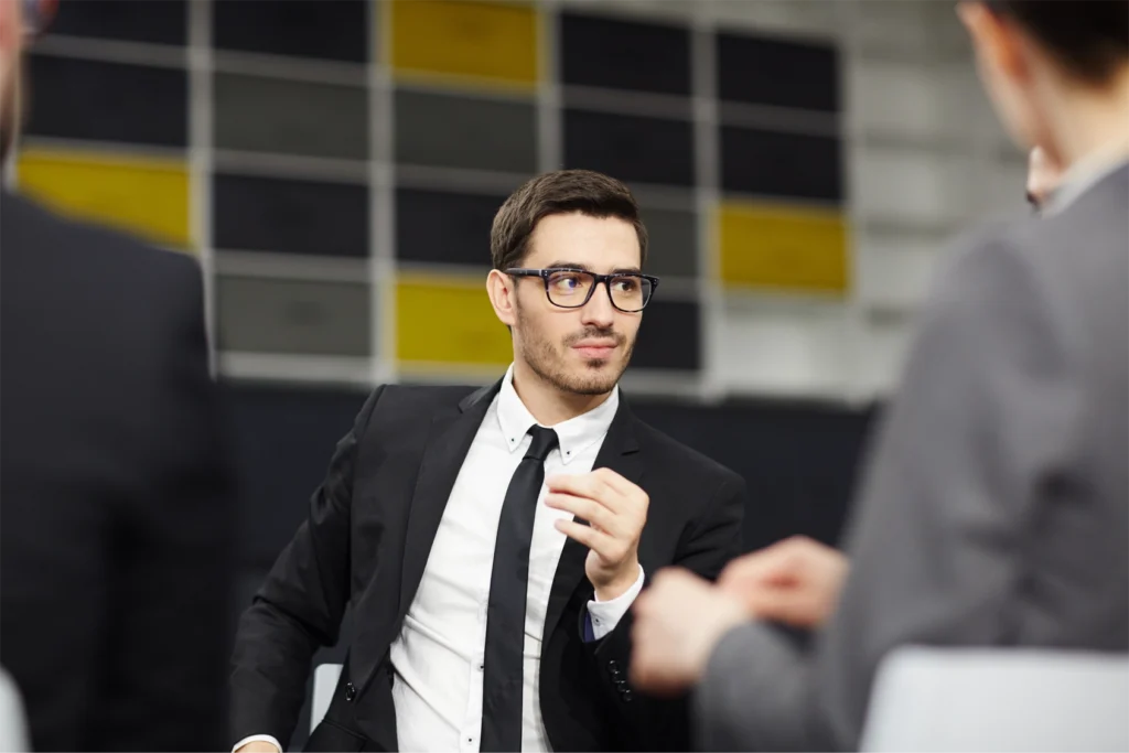 A man in a suit addressing two other people